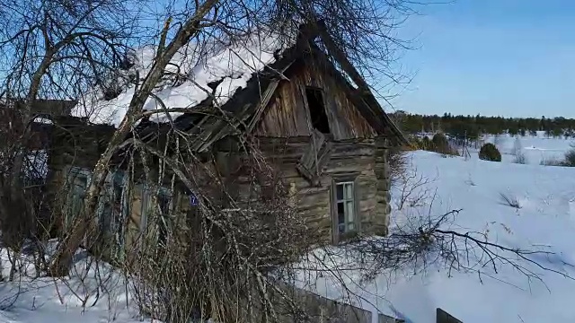 一个典型的西伯利亚村庄。冬天。房顶上有很多雪。传统的俄罗斯木屋是小屋。视频素材