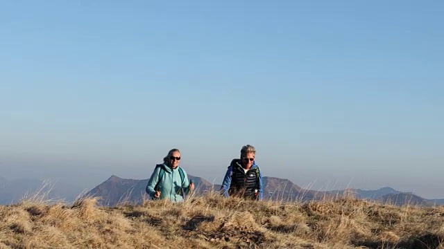 一对徒步旅行的夫妇向山顶跋涉，看那边视频素材