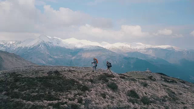 山地车下降的山脊经过徒步旅行者上升的鸟瞰图视频素材