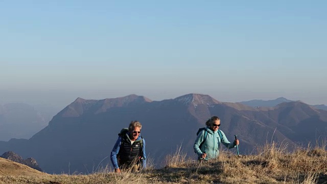 一对徒步旅行的夫妇向山顶跋涉，看那边视频素材