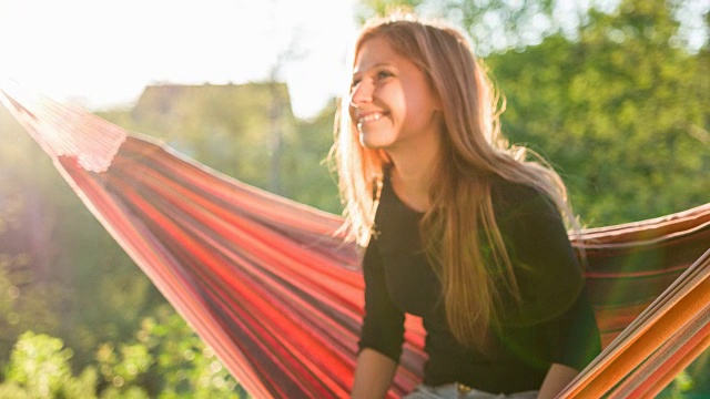 美丽的女人在吊床上摇摆，做着白日梦视频素材