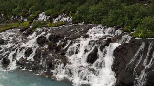 宽高角度拍摄瀑布流入河/ Hraunfossar，冰岛视频素材