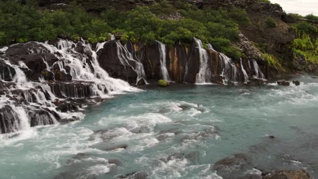 宽摇摄瀑布流入河/ Hraunfossar，冰岛视频素材