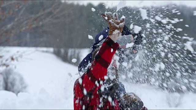 父亲和儿子在冬天暴风雪的户外玩耍视频素材