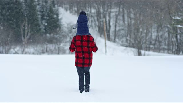 父亲和儿子在冬天暴风雪的户外玩耍视频素材