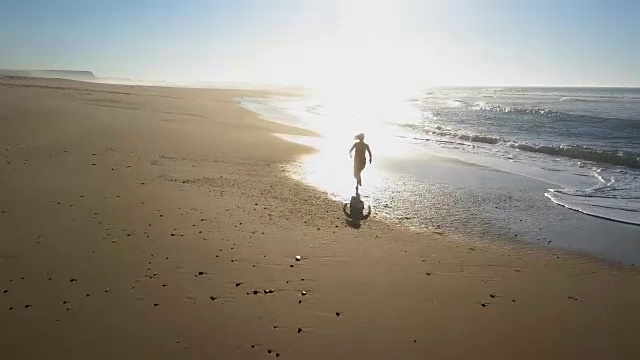 女人沿着海滩慢跑，水花四溅视频素材