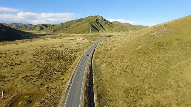 航拍的道路延伸到遥远的地平线上的草原，中国甘肃。视频素材