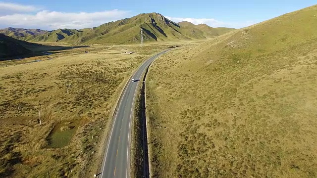 航拍的道路延伸到遥远的地平线上的草原，中国甘肃。视频素材