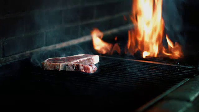 t骨牛排肉在烧烤烤架上烹饪视频素材