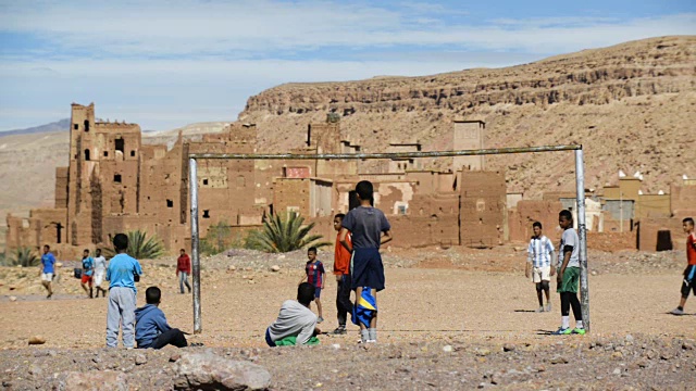 北非摩洛哥，Ait Benhaddou附近的Assfalou村，孩子们在摩洛哥卡斯巴附近踢足球视频素材