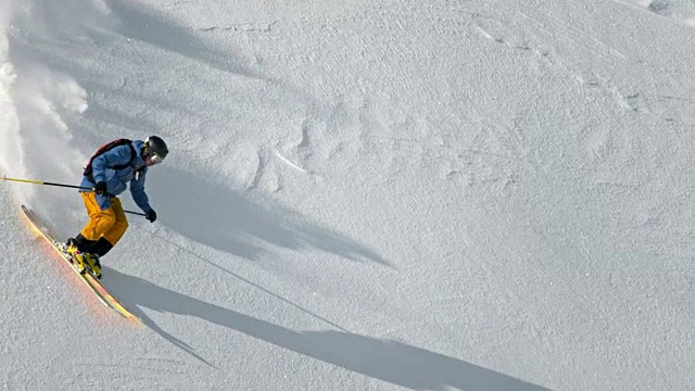 SLO MO男性野外滑雪者滑雪下山阳光照耀的山视频素材