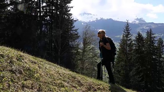 徒步旅行的夫妇沿着草地山脊，山脉的轨迹视频素材