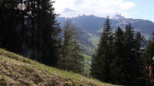 徒步旅行的夫妇沿着草地山脊，山脉的轨迹视频素材