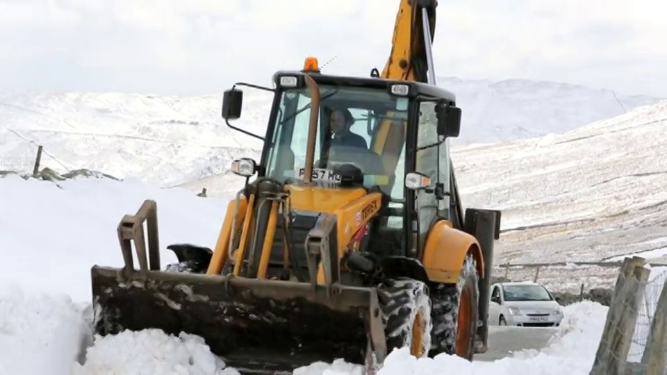 一名JCB医生试图在巨大的积雪中清理出一条路视频下载