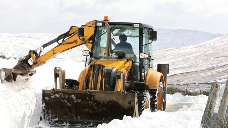 一名JCB医生试图在巨大的积雪中清理出一条路视频下载