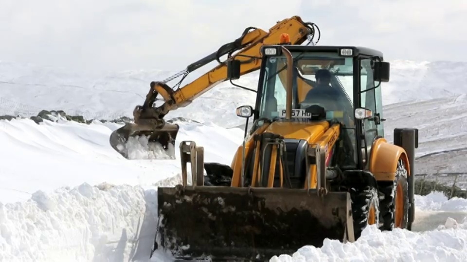 一名JCB医生试图在巨大的积雪中清理出一条路视频下载