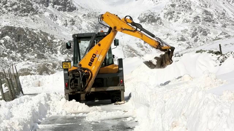 一名JCB医生试图在巨大的积雪中清理出一条路视频下载