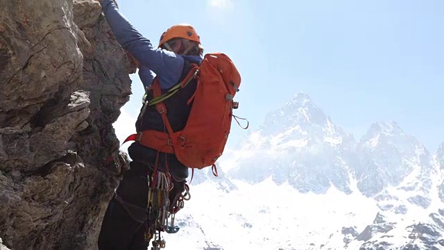 男性登山者攀登垂直岩壁以上的mtns，山谷视频素材