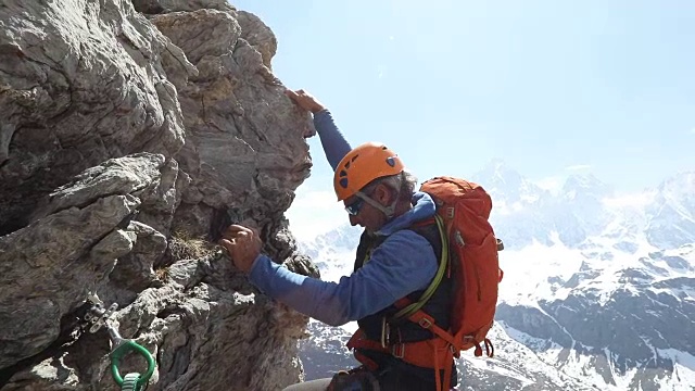 男登山家攀登岩石，向队友伸出援手视频素材