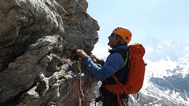 男登山家攀登岩石，向队友伸出援手视频素材