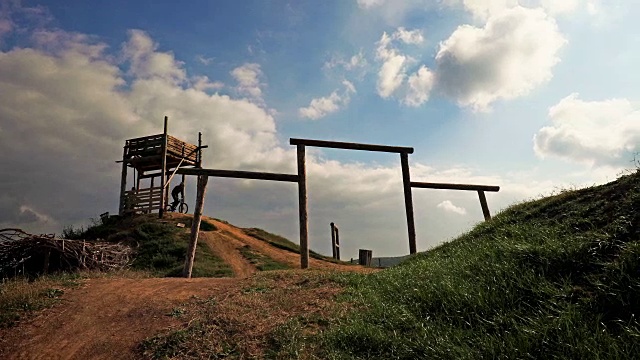 骑山地车的人在天空中跳过土山。缓慢的运动。视频素材