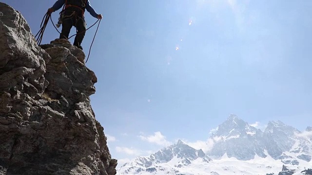 男登山家向队友扔绳子，山视频素材