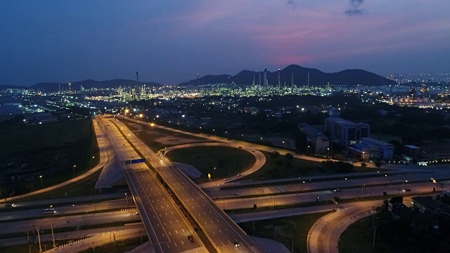 黄昏时分公路交通及炼油厂鸟瞰图视频下载