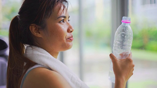 亚洲女人在健身房喝水视频素材