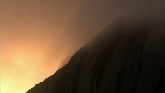 黄昏时分，云在岩石嶙峋的山腰上飘荡视频素材