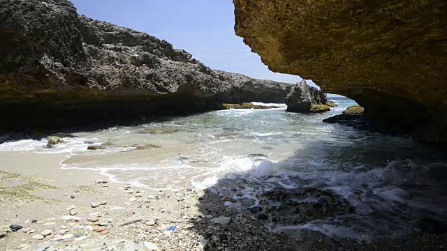 夫妻沿着海滩边散步，海岸岩石视频素材