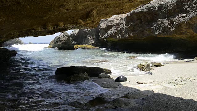 女人走在海滩边，海岸岩石视频素材