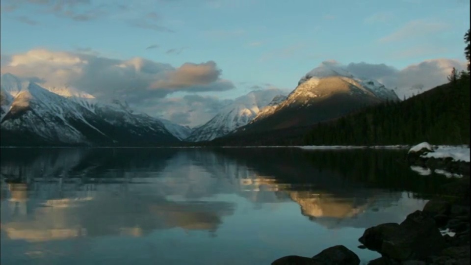 在冰川国家公园里，麦克唐纳湖的湖水映出白云在雪山上移动。视频素材