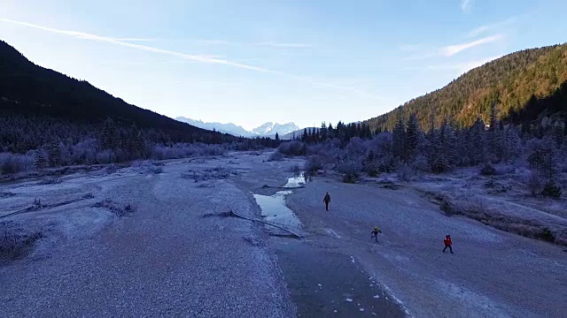 母亲和孩子们走在结冰的河床上视频素材