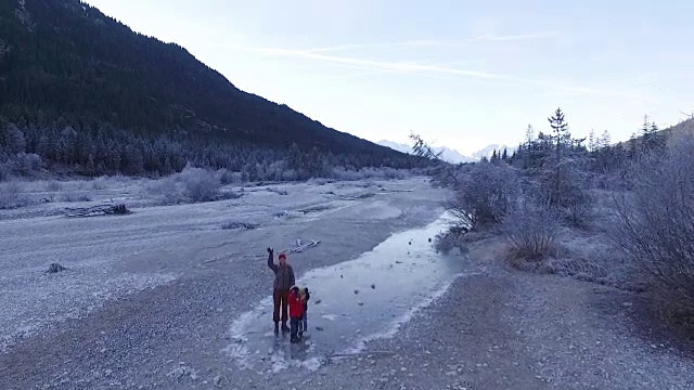 母亲和孩子们走在结冰的河床上视频素材