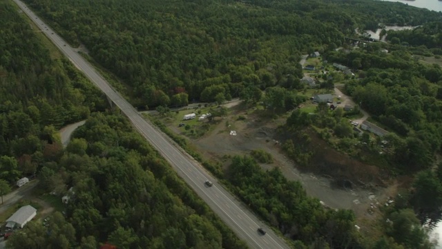 汽车在乡村道路上行驶的空中跟踪镜头。林中的树林中的树视频素材