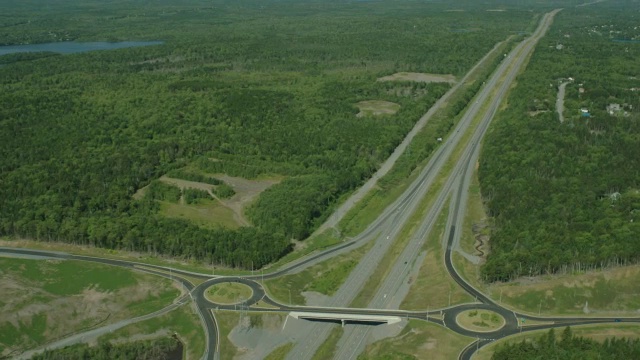 穿越乡村或农村地区的公路的航拍。林中的树林中的树视频素材