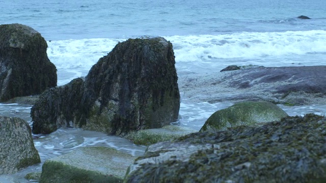 潘从左到右的海浪击中了岸上的岩石。可能是海滩。可能是湖泊或海洋。视频素材