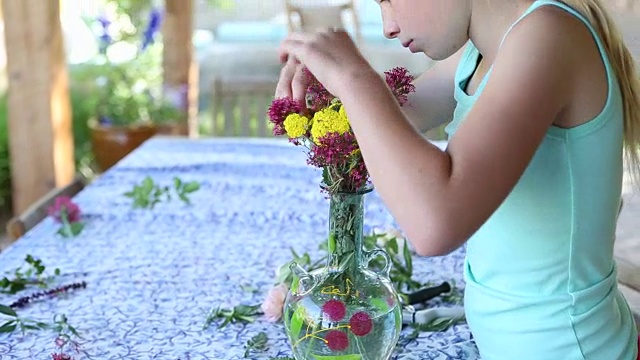 女孩在她的花园里采摘和插花视频素材