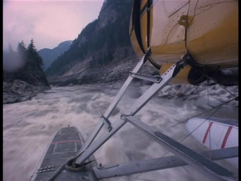 从水上飞机的浮桥上从空中飞过，它正飞过水面上的一个河流峡谷。视频素材