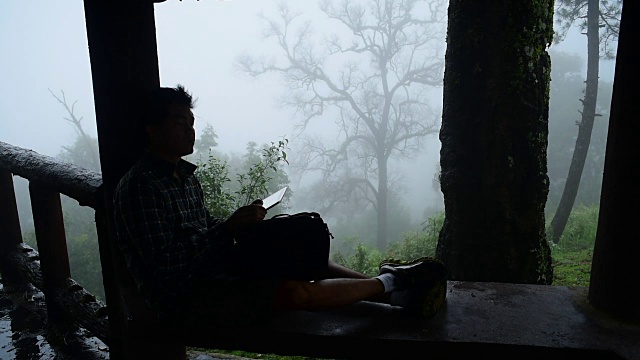 徒步旅行者在热带雨林中使用平板电脑放松视频素材