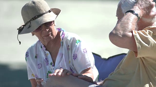 一对老年夫妇在海滩上用润肤露视频素材