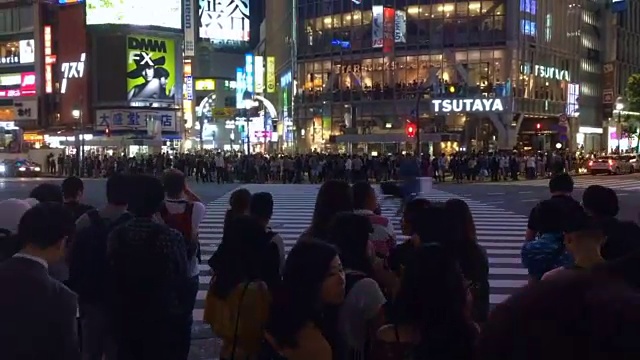 这是涉谷熙熙攘攘的人行横道，白天上班，晚上开车。视频素材