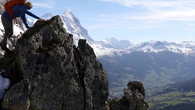 女登山家攀登山巅，峡谷之上的岩石视频素材