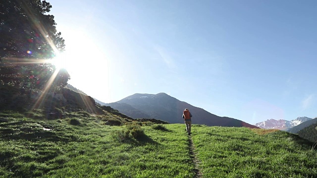 一个徒步旅行者在日出时沿着小路向山上走去视频素材