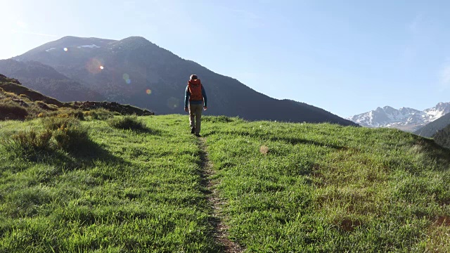 一个徒步旅行者在日出时沿着小路向山上走去视频素材