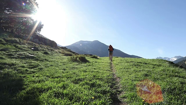 一个徒步旅行者在日出时沿着小路向山上走去视频素材