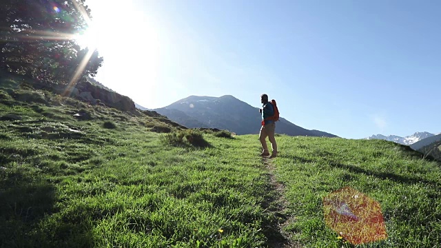 一个徒步旅行者在日出时沿着小路向山上走去视频素材