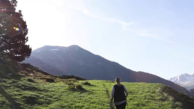 一个徒步旅行者在日出时沿着小路向山上走去视频素材