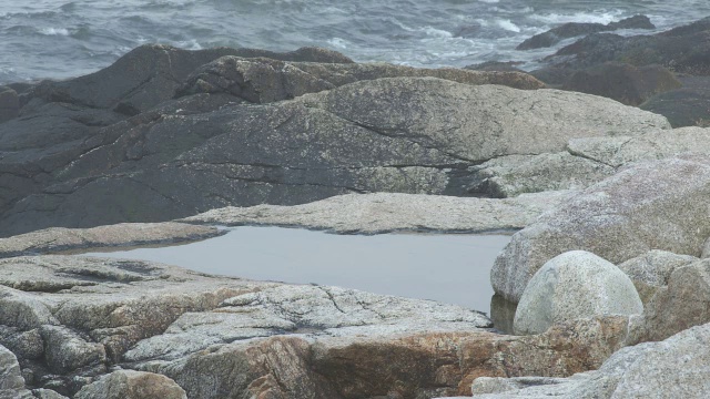 靠近岸边岩石的角度。潮间带水坑。可能是海滩。可能是湖泊或海洋。视频素材