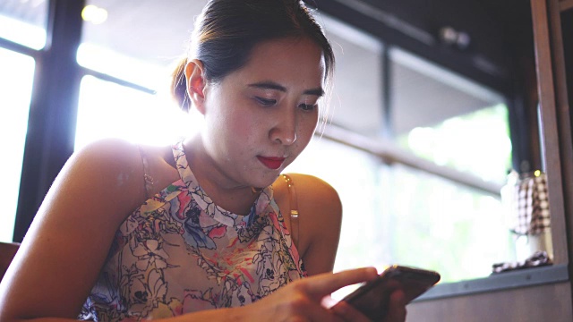 女人在咖啡馆玩手机。视频素材